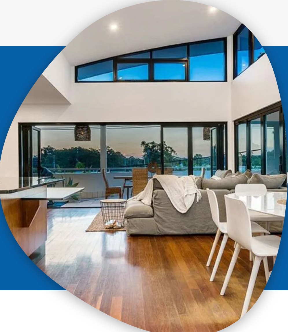 Open-plan living room with high windows and timber floors